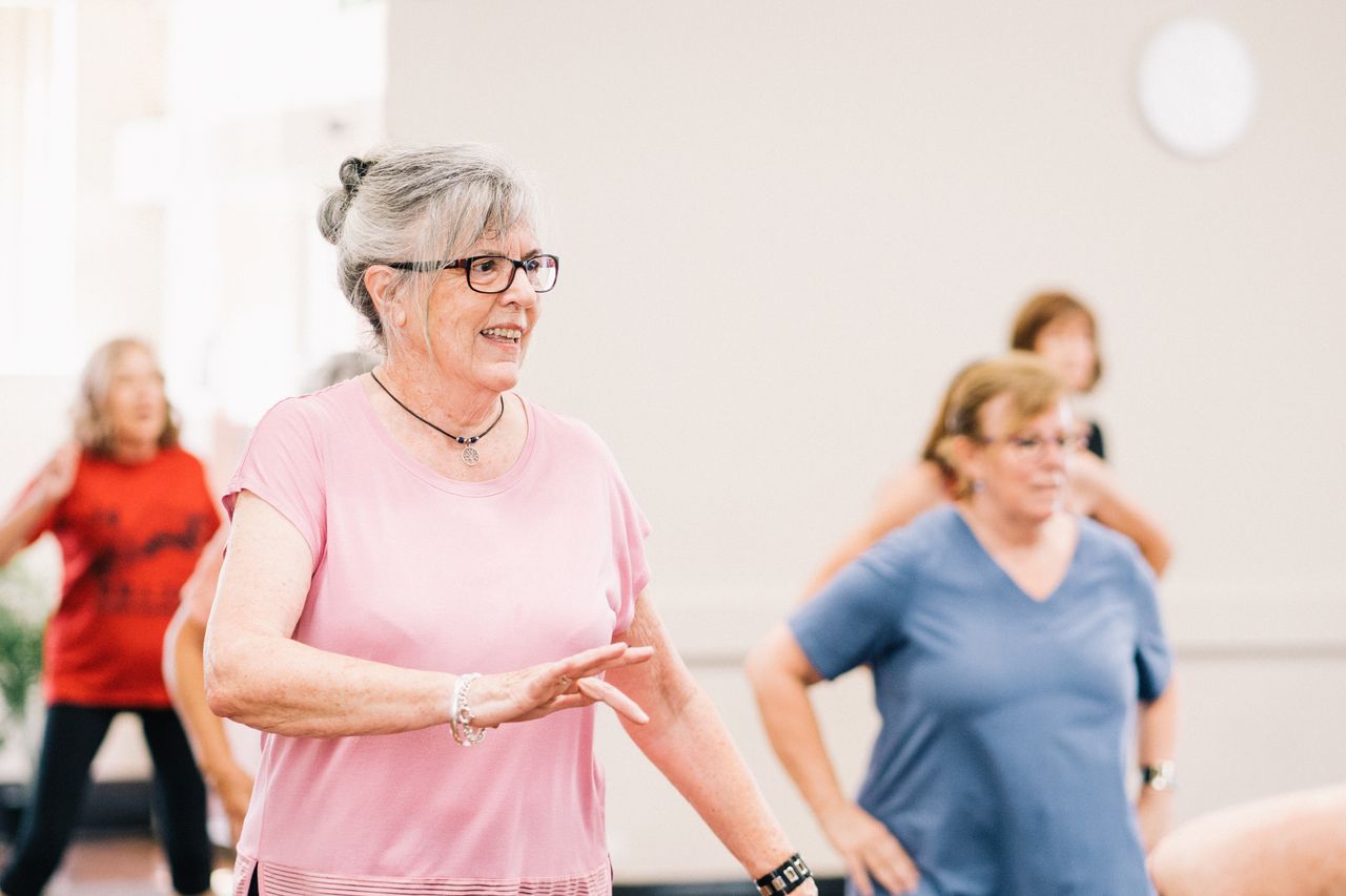Mastering the First Impression: Your intriguing post title goes here Senior women participating in a lively and joyful group exercise session indoors.